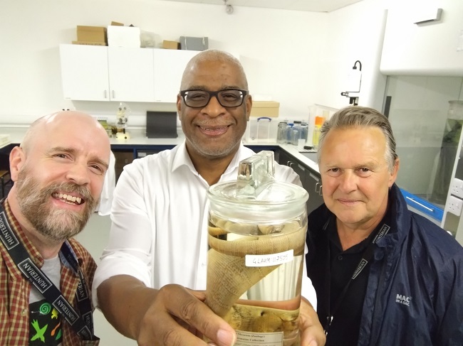 (L-R) Mike Rutherford, Zoology Curator, The Hunterian, University of Glasgow, Professor Simon Anderson, Board Director of the GCCDR holding the wet specimen of the Jamaican Giant Galliwasp and Steph Scholten, Director, The Hunterian, University of Glasgow. Photo Mike G Rutherford.