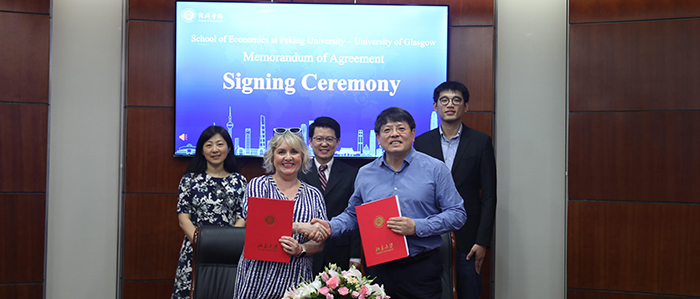 Head of Adam Smith Business School standing for a group photo with associates in China, signing a Memorandum of Agreement