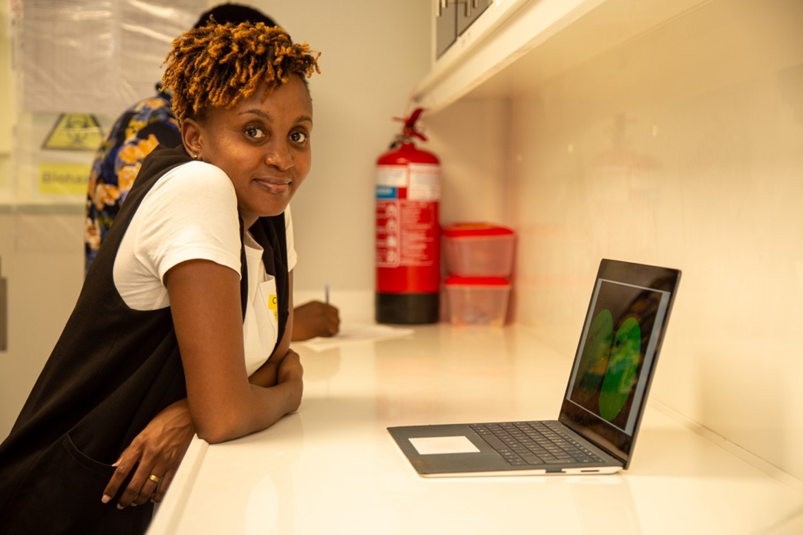 A student standing in front of the computer that is on the laboratory bench