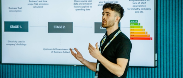 Man lecturing in front of digital screen