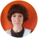 Constance smiles at the camera in front of an orange background. She has short brown hair.