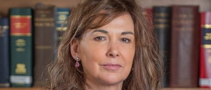 A portrait of a woman with books in the background