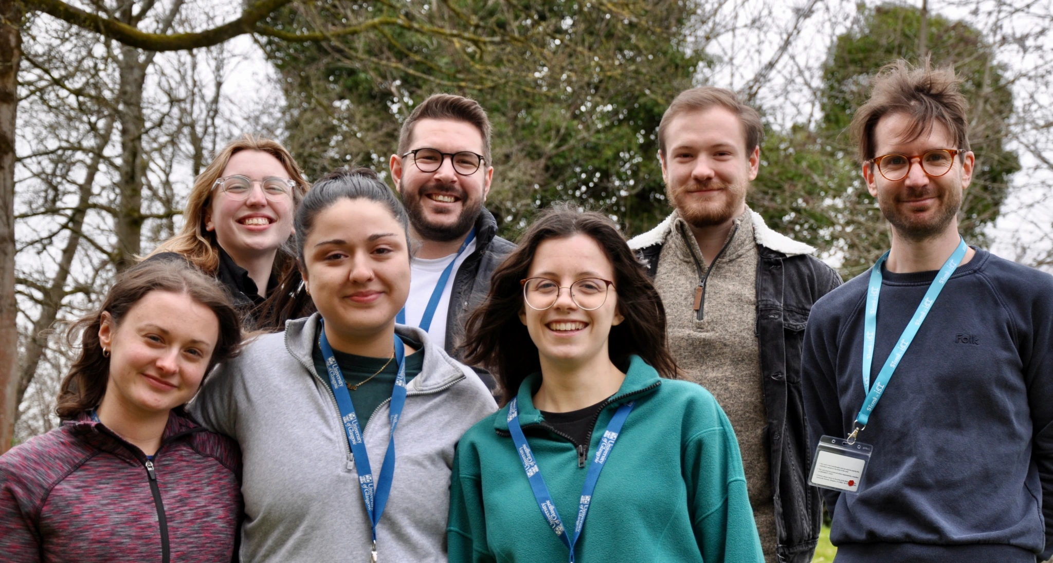 Seven people stood in a group in front of a tree.