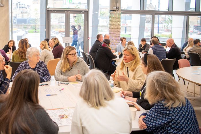 Groups of people sitting at tables chatting.
