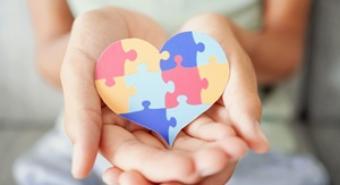 Hands holding a heart made of jigsaw puzzle pieces