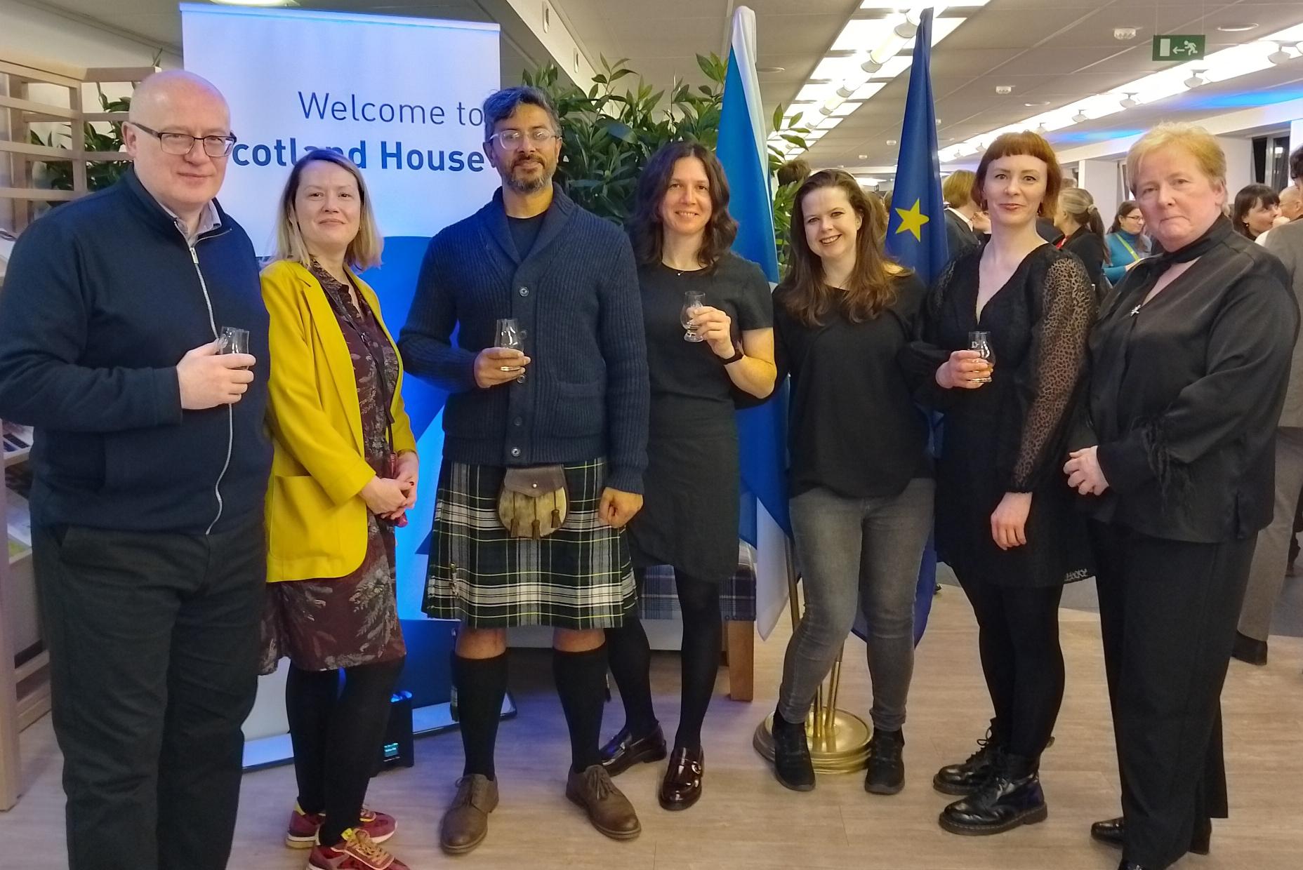 Seven staff members, Scotland House banner, EU flags