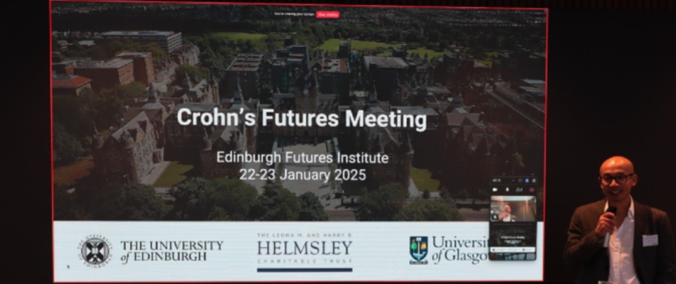 Professor Gwo-Tzer Ho stood at a podium in front of a large screen showing a cover slide at the Crohn's Futures Meeting