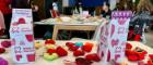 A table with knitted hearts and fundraising boxes for the British Heart Foundation