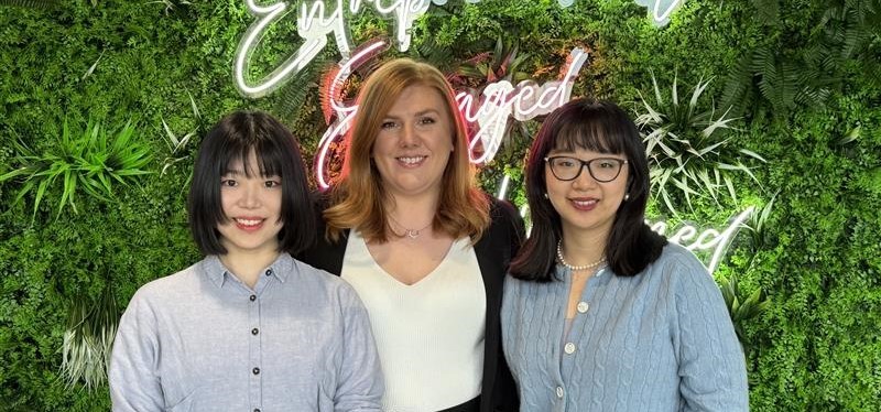 Three female members of the Alumni team pose in the ASBS building foyer.