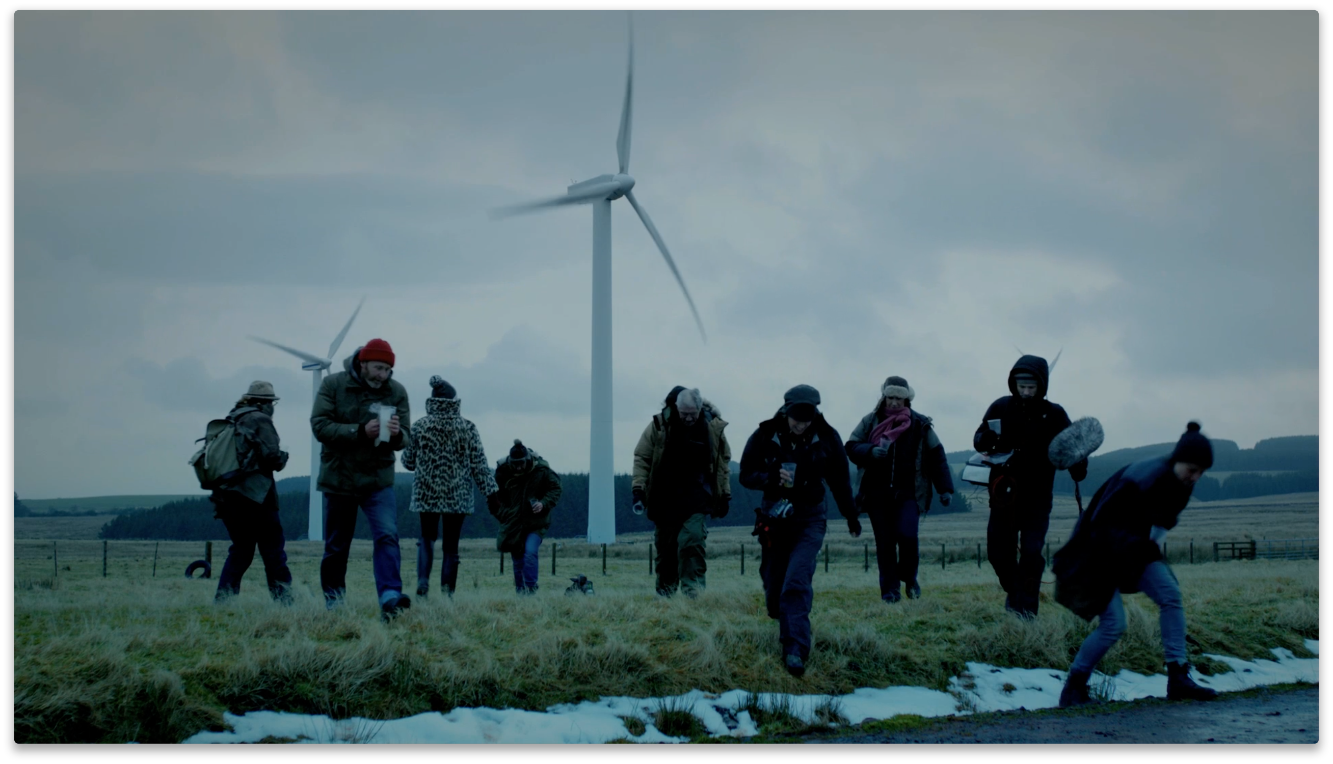 Productions staff walking away from a wind turbine