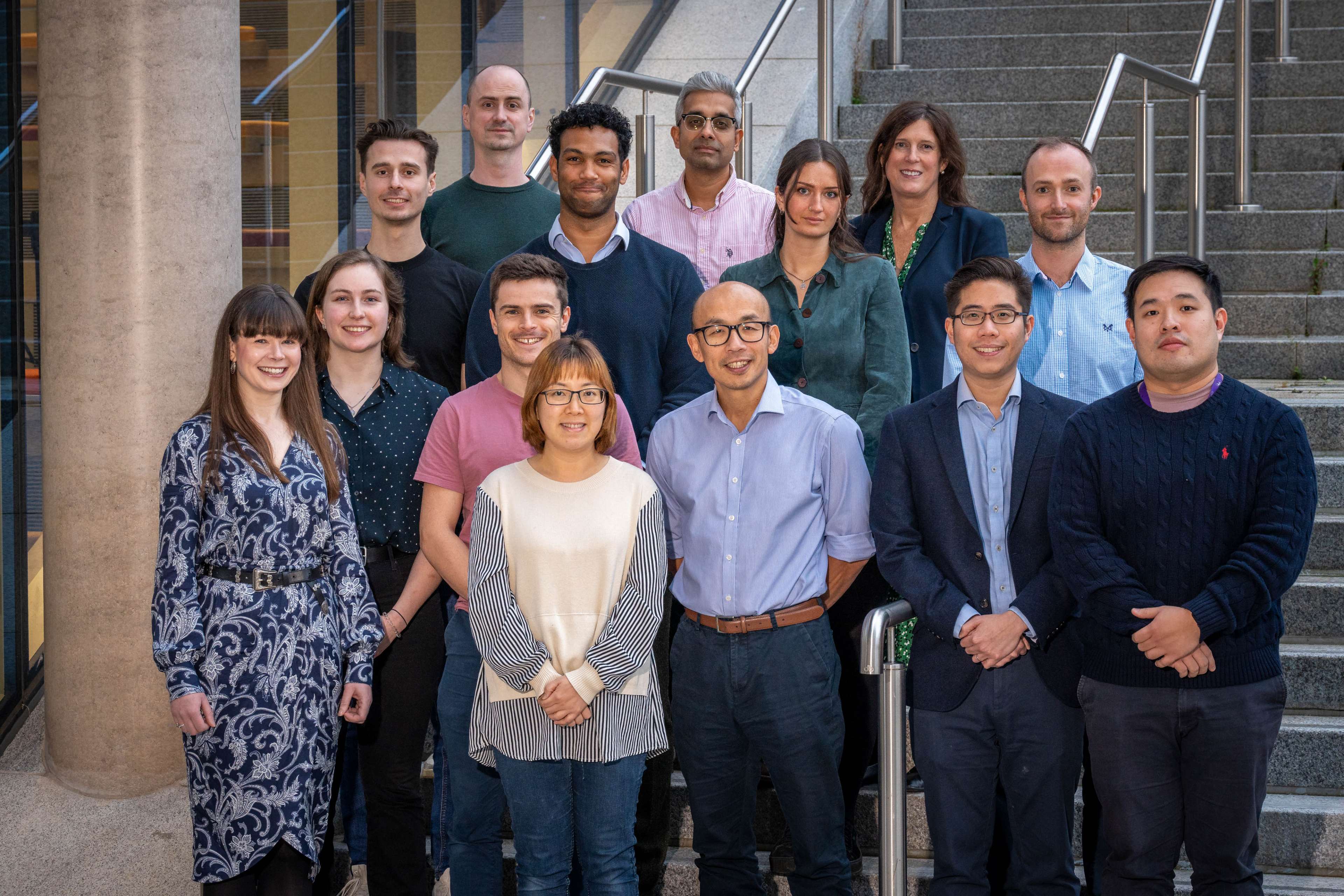 Individual members of the The Gut Translational Research Group gathered together and stood on steps facing the camera