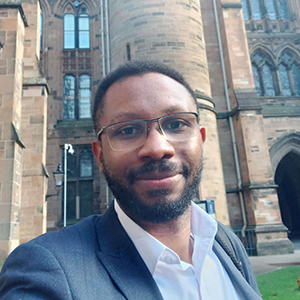 Dr Nnanna Oledibe, Lecturer in Finance (Accounting & Finance), standing in the West Quadrangle, University of Glasgow