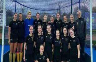 Woman's hockey team standing in front of goal