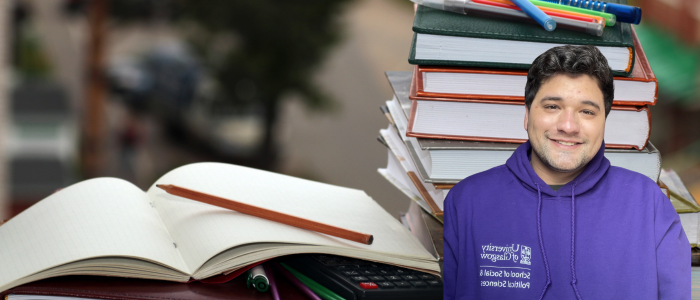 Open textbook next to a pile of books with headshot of a smiling man