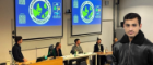 Panel of students in front of the International Relations society with headshot of smiling man