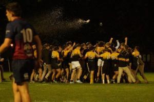 Men's rugby game team on pitch celebrating