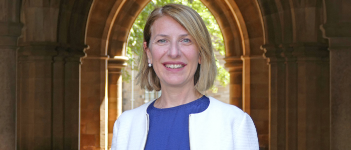 Professor Nuran Acur underneath an archway in the cloisters