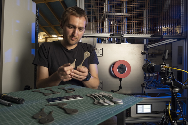 Charlie Patterson of the James Watt School of Engineering examines samples of 3d-printed material tested in the NextSpace TestRig