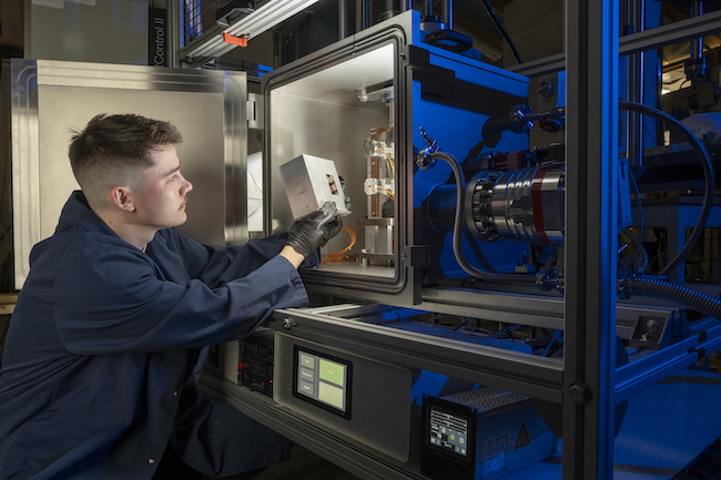 Matthew Deans of the James Watt School of Engineering loads a cartridge of 3d-printed material samples into the NextSpace TestRig for testing