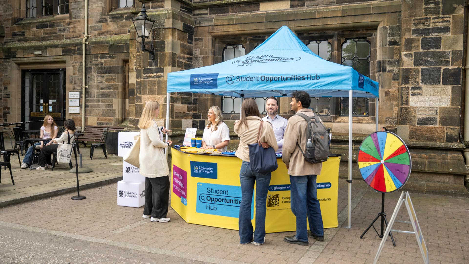 Employers speaking to students at a pop-up in front of the Gilbert Scott Building