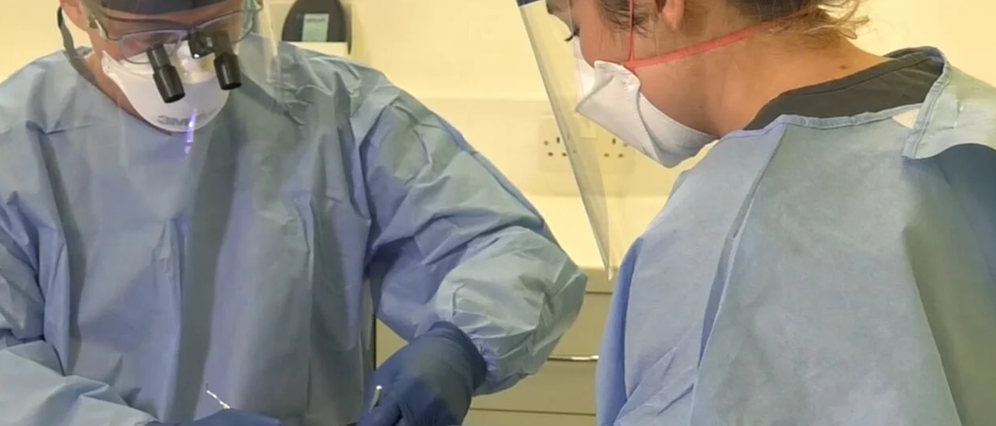 2 dentists performing a procedure on a patient