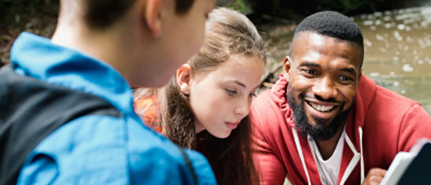 Young people and an adult looking at a piece of paper