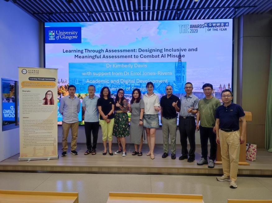 A group picture of the attendees of the workshop on front of a screen