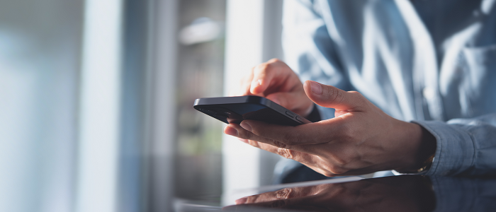 Image shows a hand holding a mobile phone
