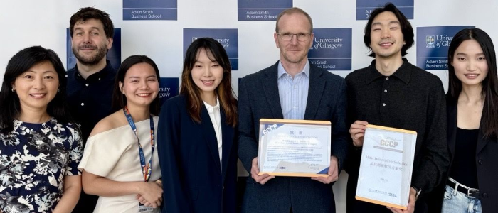 Winners of the ZIBS Global Corporate Consulting Project 2025 standing for a group photograph with their certificate beside three Adam Smith Business School academic staff