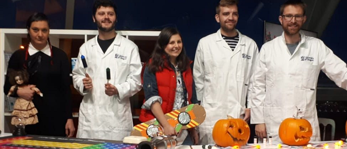 Students in lab coats with pumpkins