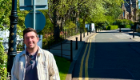Dr Liam Rooney stood on the pavement, with the Sir Gilbert Scott Building in the background