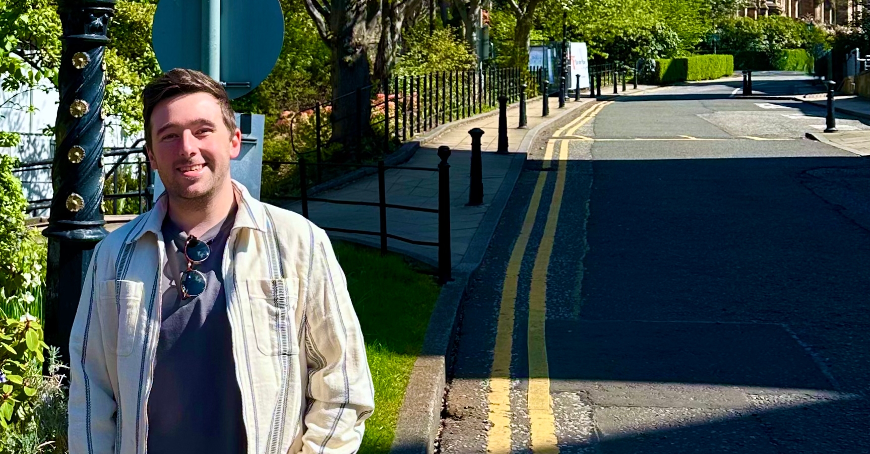 Dr Liam Rooney stood on the pavement, with the Sir Gilbert Scott Building in the background