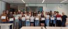 Students from ASBS and Radboud University standing together, holding their programme completion certificates, with a member of staff standing on either side of the group