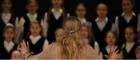 An image of a woman conducting a children's choir