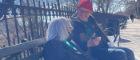 Man and woman sitting on a bench in the winter sun talking