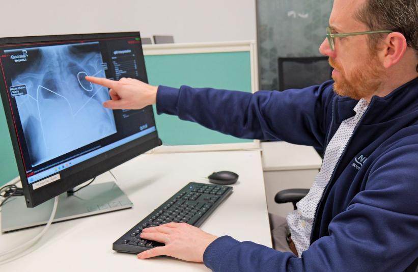 A clinician reviewing a lung scan for abnormalities