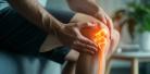 AI-generated image of person holding their knee, with the bone visible in orange and yellow