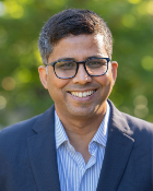 A head and shoulders portrait shot of Dr Srustidhar Das outdoors against a background of foliage
