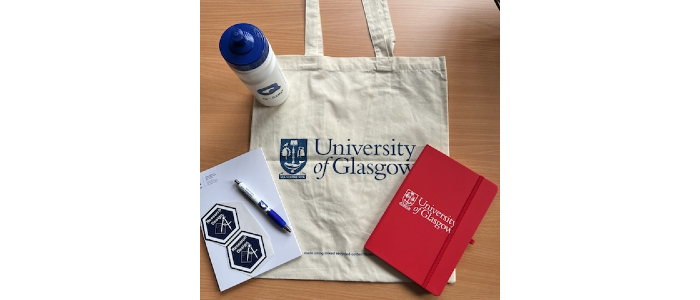 Image of a UofG merchandise, bag, cup, pen and paper