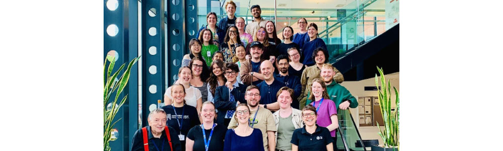Participants and organisers from the 2025 Strathclyde Optical Microscopy Course (SOMC) stood together on steps in a modern building