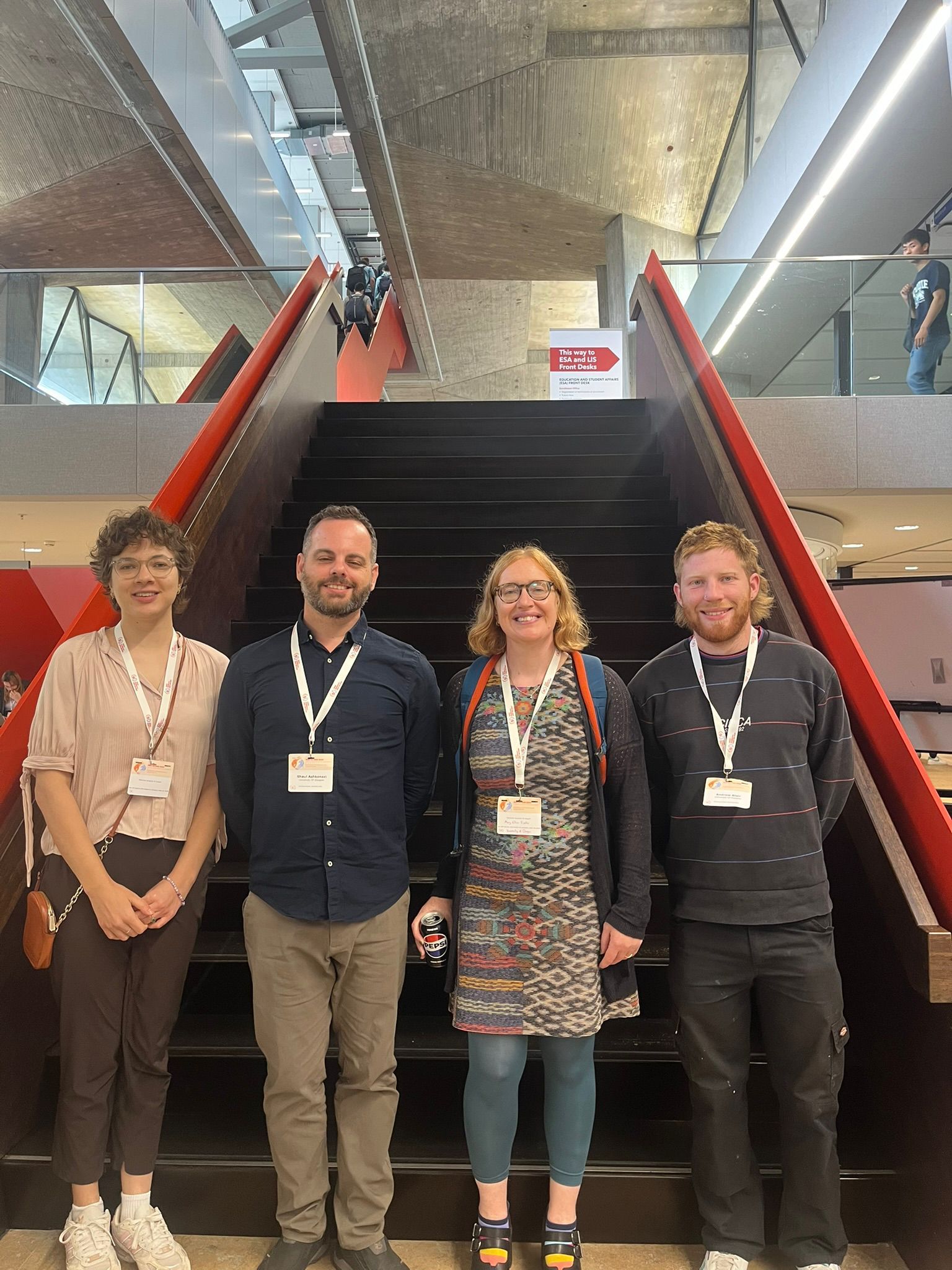 Four people standing on staircase looking at the camera