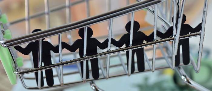 Paper people imprisoned in a shopping cart