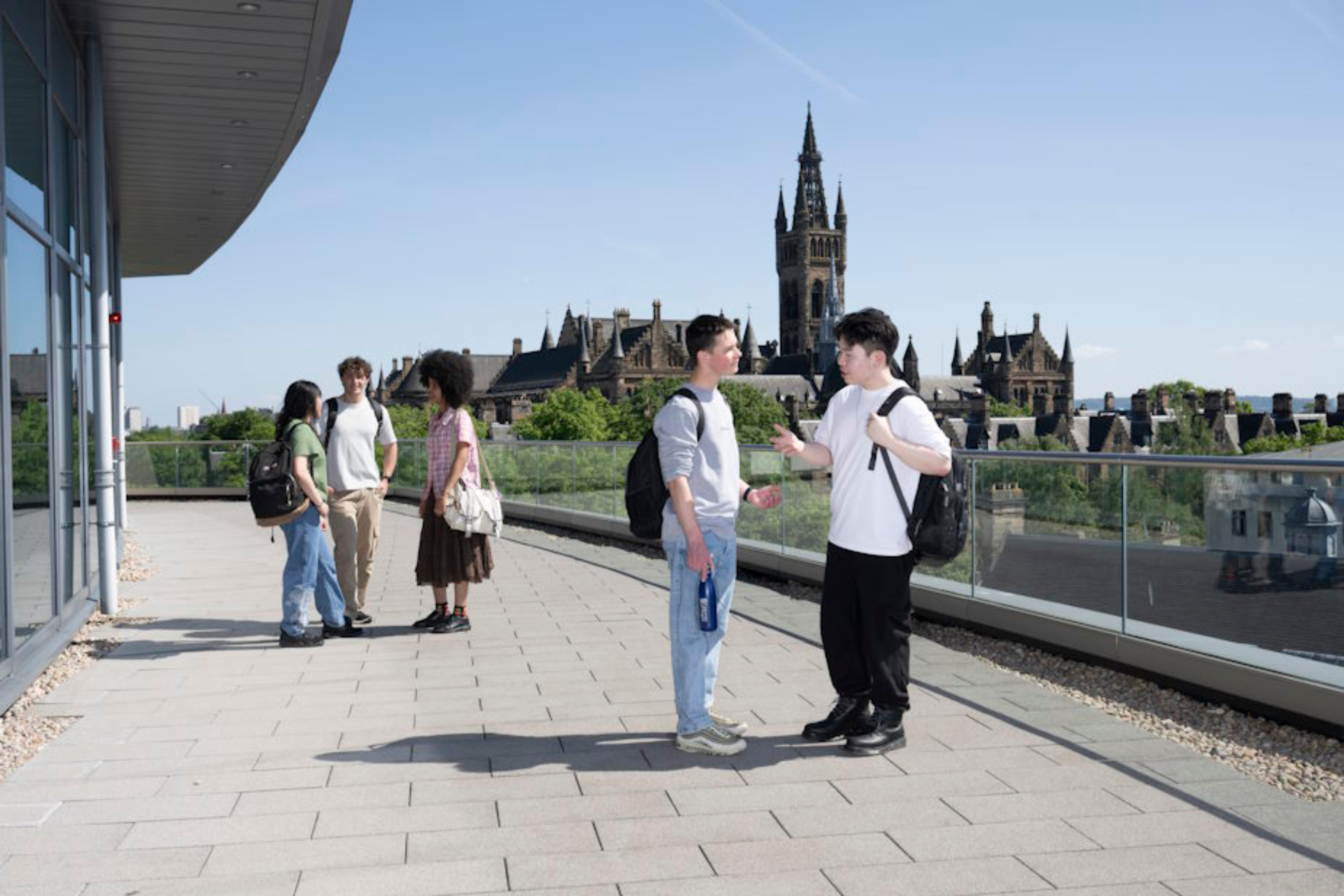 Three students congregating on the steps outside a University Building