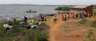Image of a group of African people on a beach next to a treatment hut