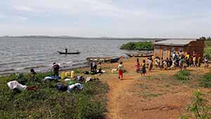 Image of a group of African people on a beach next to a treatment hut