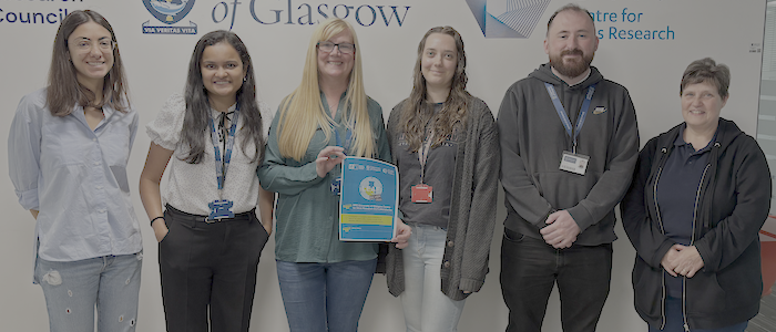 CVR sustainability team - 5 women and a man - holding the LEAF silver certificate in front of decals of the centre logo on a white wall