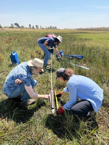 The team preparing the core for description and photography. Front, from left to right: Prof. Frank Neumann and Dr. Bianca Cavazzin. In the background: students Tshiamo Mmatladi and Thokozani Mahlangu. Photo credit: Alexandra Vasilyeva.