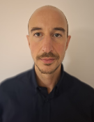 A head and shoulders portrait shot of Matteo Turco set against a plain, light background
