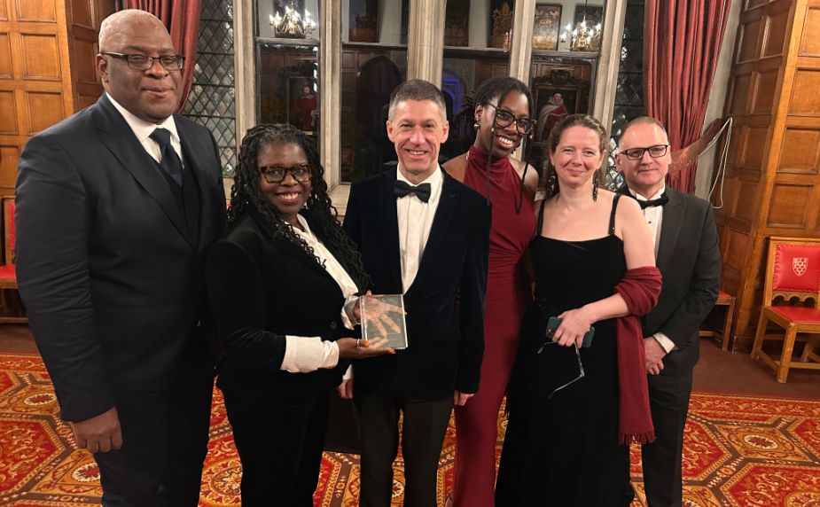 Professor Simon Anderson, Co-Director of the Glasgow Caribbean Centre for Development Research; Dr Peggy Brunache, Director of the Beniba Centre for Slavery Studies; Dr David Duncan, UofG's Chief Operating Officer & Deputy Vice Chancellor; Taylar Carty, James McCune PhD scholar; Dr Christine Whyte, Historian and Dr Stephen Mullen, Historian and co-author of the 2018 Slavery, Abolition & the University of Glasgow report are photographed with the UWI Chancellor's Award.