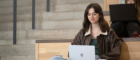 A student sitting in the JMSLH looking at a laptop